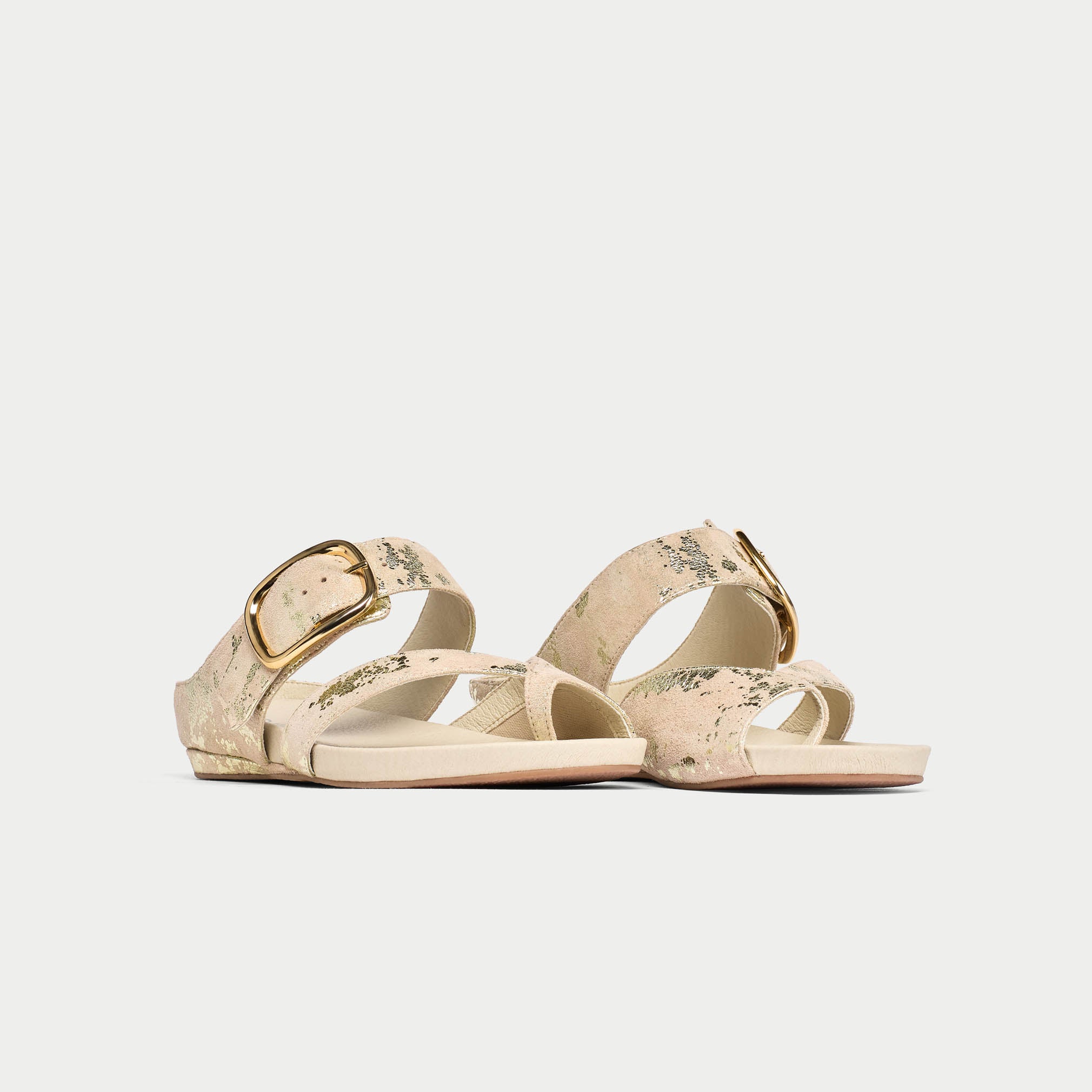 Beige sandals with gold buckle on a light gray background