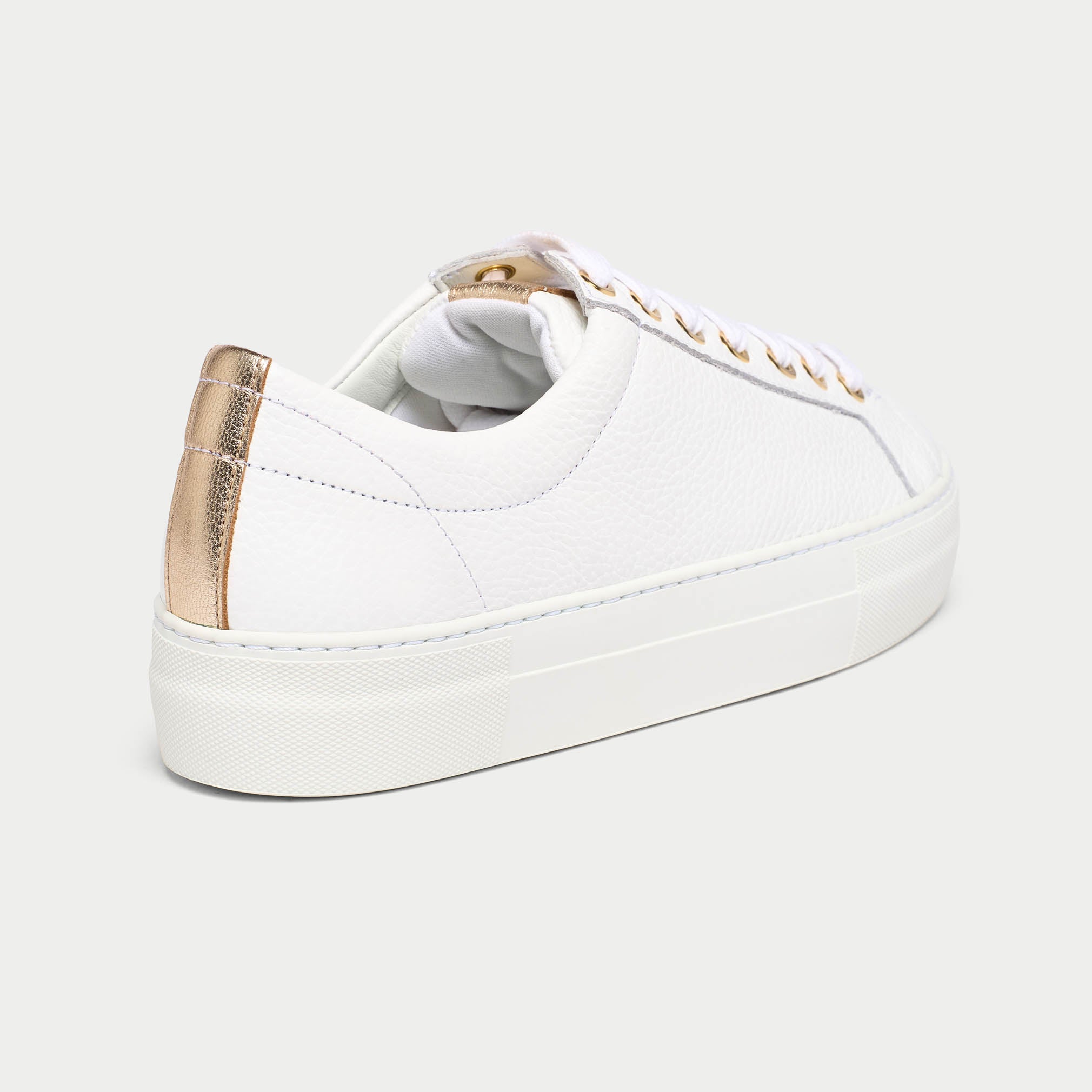 White saturn sneaker with gold accents on a light gray background heel close-up