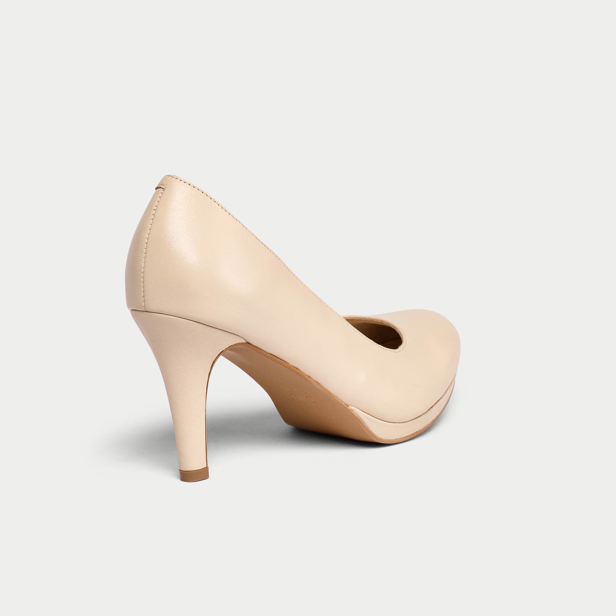 Beige high-heeled shoe on a light gray background
