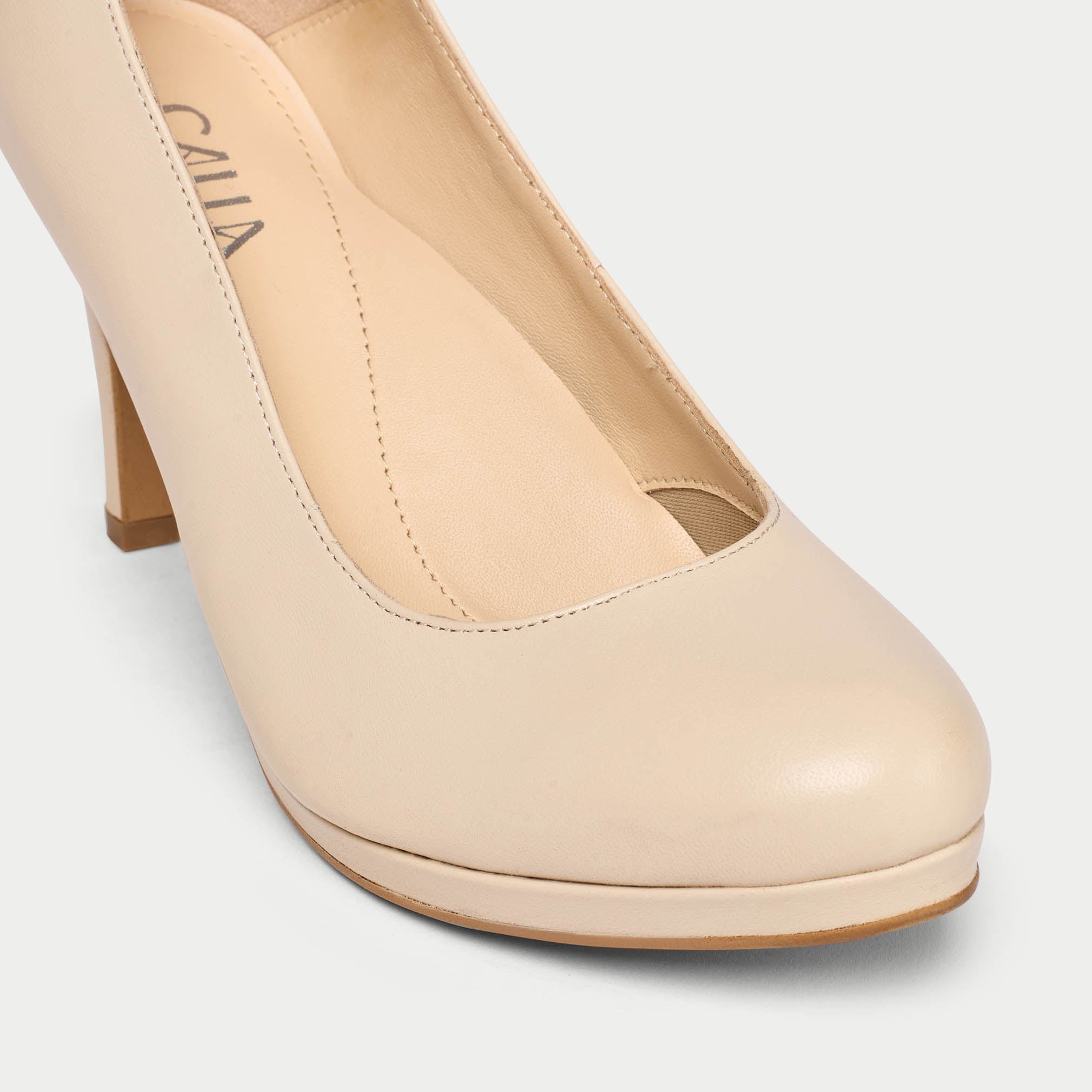 Beige high-heeled shoe on a light gray background