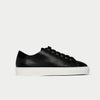 Black leather sneaker with white sole on a light gray background