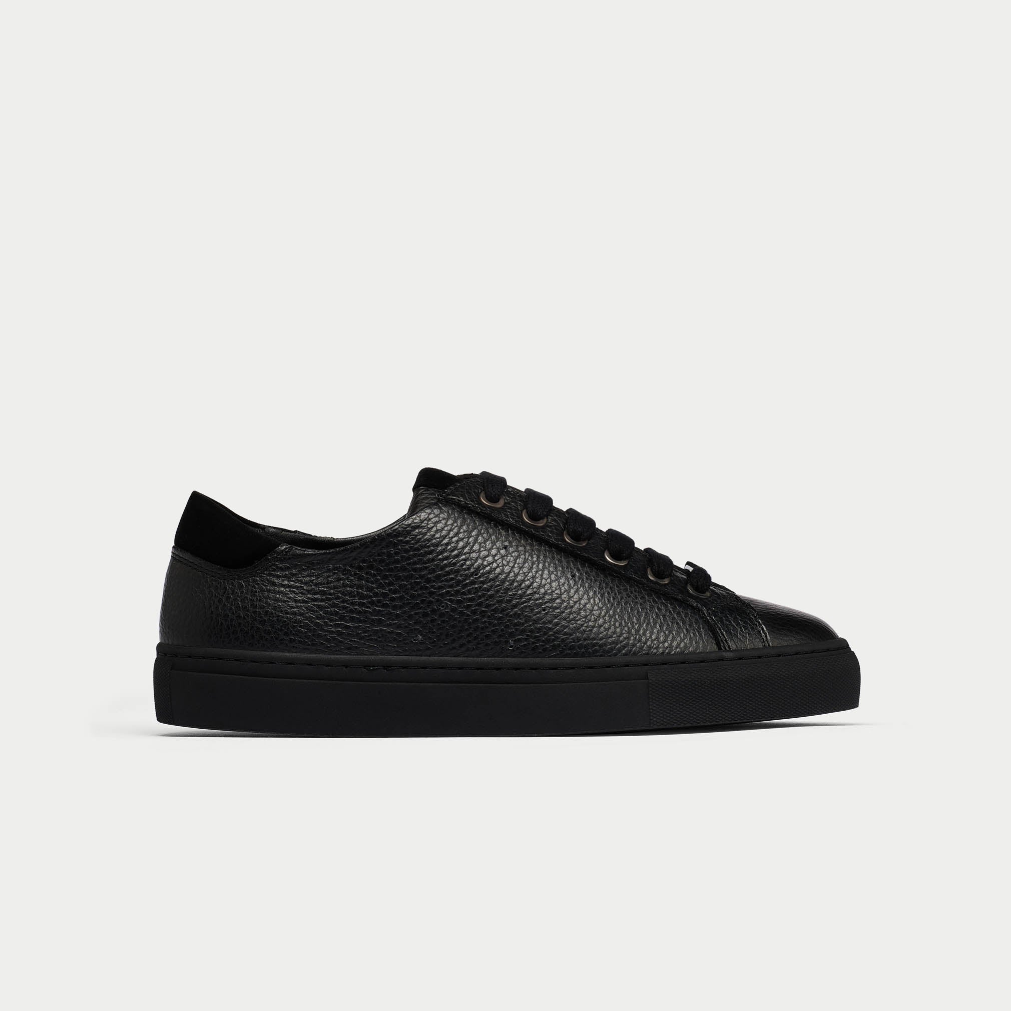 Black leather sneaker on a light gray background