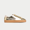 Gold metallic sneaker with tan sole on a light gray background