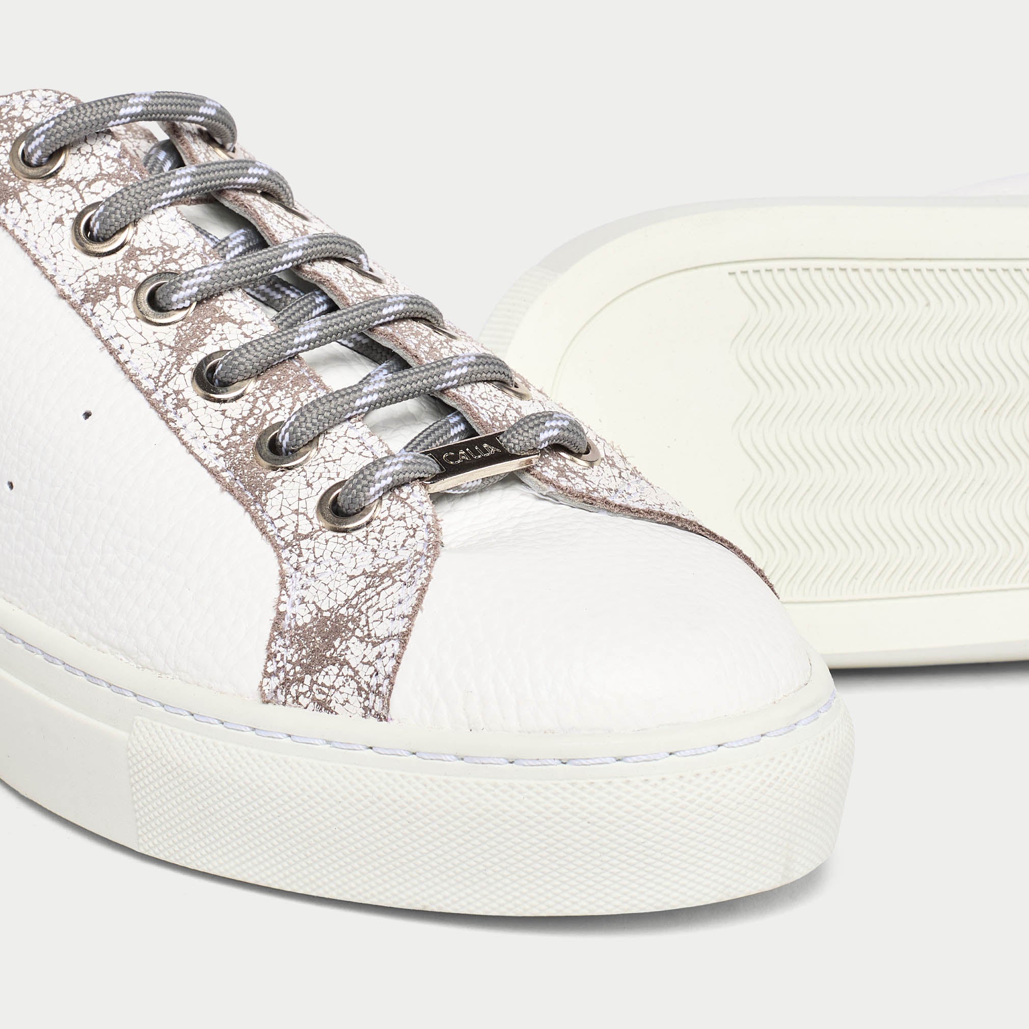 White sneaker with greycrackle side panel and grey laces on a white background