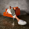 model sat on chair wearing Calla trainers