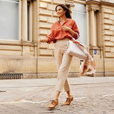 woman walking down the street in tan leather shoes